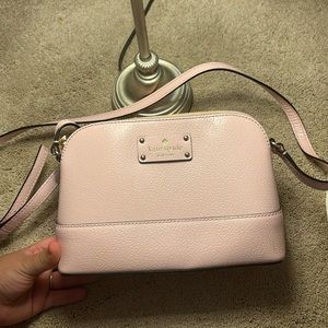 light pink crossbody kate spade bag.